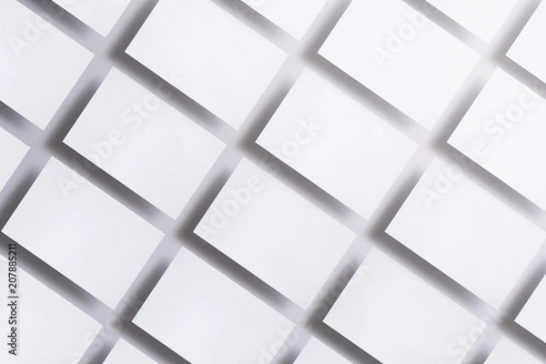 Fototapeta Photo of blank business cards on white. Mock-up for branding identity. For graphic designers presentations and portfolios. business cards stacks arranged in rows at white textured paper background.