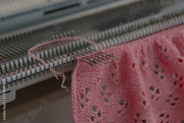 Fototapeta Manual knitting machine. A knitting machine is a device used to create knitted fabrics