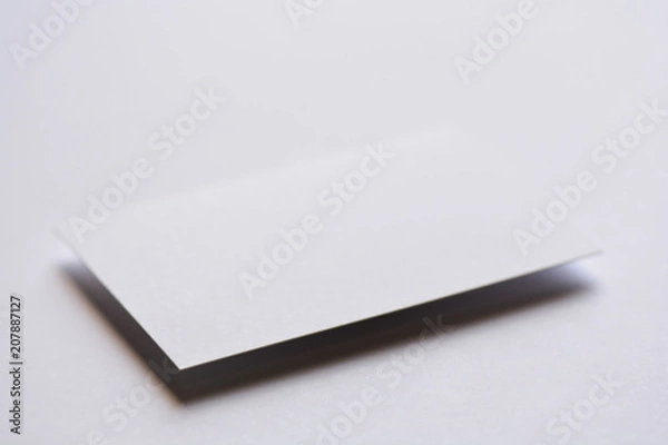 Fototapeta Photo of blank white business cards on white. Mock-up for branding identity. For graphic designers presentations and portfolios