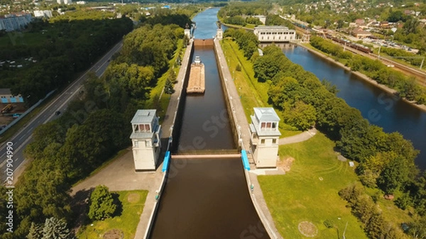 Fototapeta Sluice Gates on the River. Aerial view barge, ship in the river gateway. River sluice construction, water river gateway. Shipping channel.