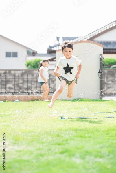 Fototapeta 庭で水遊びをする男の子