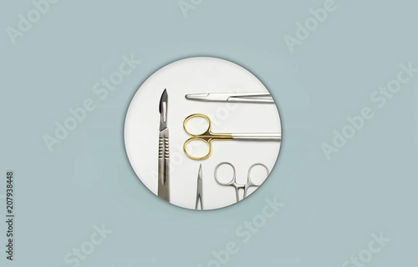 Obraz Surgical instruments in white circel in the center of a light blue background