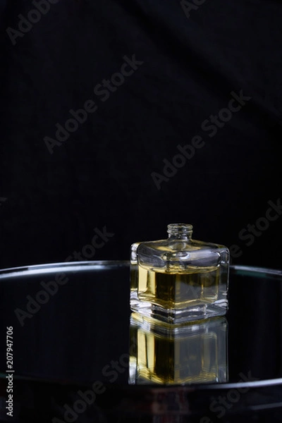 Obraz Yellow bottle of perfume spraying, isolated on black background