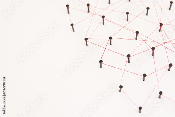 Obraz Linking entities, social media, Communications Network, The connection between the two networks. Network simulation on white paper linked together with a red thread with copy space