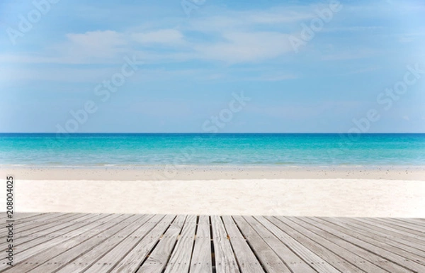 Fototapeta Old empty wooden pier perspective with sandy beach.Sand beach and Beautiful sea background in summer.