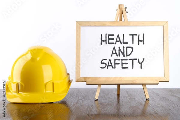 Fototapeta Safety helmet and white board with words Health and Safety,Health and Safety concept.