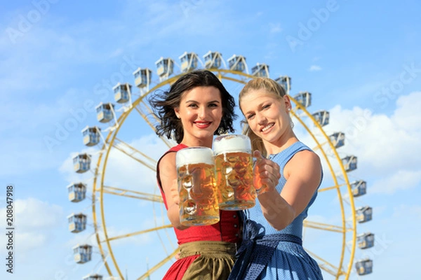 Obraz junge sexy Frau possiert auf dem Frühlingsfest, Oktoberfest, Wiesn mit Brezel, Brezn, Lebkuchenherz und prostet mit Bier, Mass Krug vor dem Riesenrad