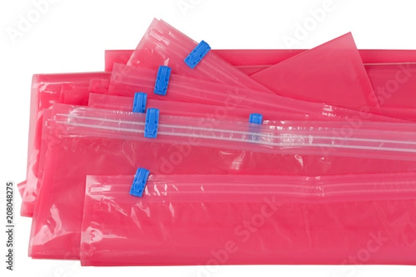 Fototapeta Różowa plastikowa torba na zamek błyskawiczny z niebieskim uszczelnieniem do pakowania odzieży do przechowywania i ponownego zamykania na białym tle