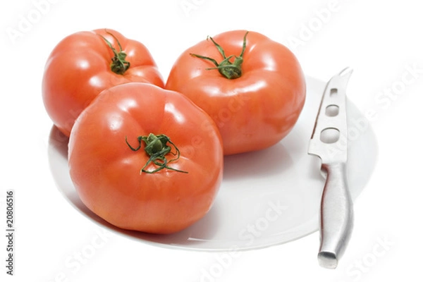 Fototapeta red tomatoes on white plate with knife