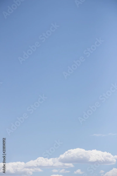 Obraz white fluffy clouds on the light blue sky background