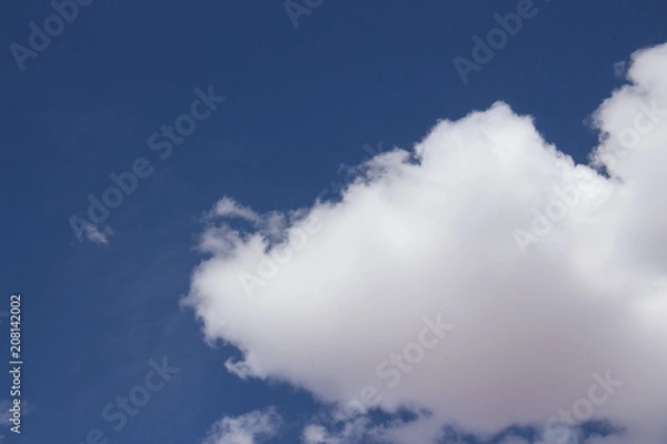 Obraz white fluffy clouds on clear blue sky background