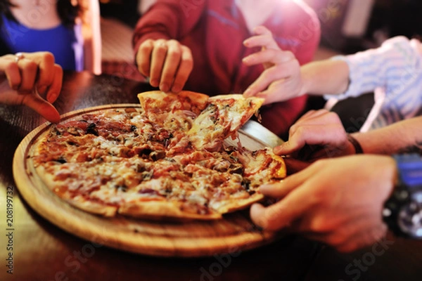 Fototapeta Ręki bierze plasterki pizzy od drewnianego talerza