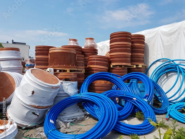 Fototapeta A warehouse of plastic pipes for various purposes, diameter and color under the open sky. Manufacture and sale of plastic products for construction works.om plastic. Drainage and sewerage. 