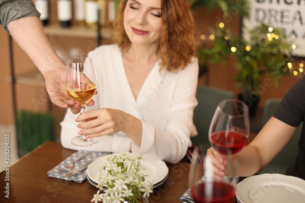 Fototapeta Waiter serving wine to client at restaurant