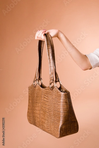 Obraz hand holding handbag on the beige background