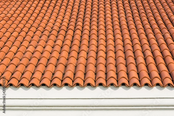 Obraz Red corrugated tile element of roof at house and white wall. Shingles roofing surface tiles overlay pattern and texture