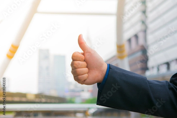 Fototapeta Handful with thumb up of business man infront of blur background in good concept