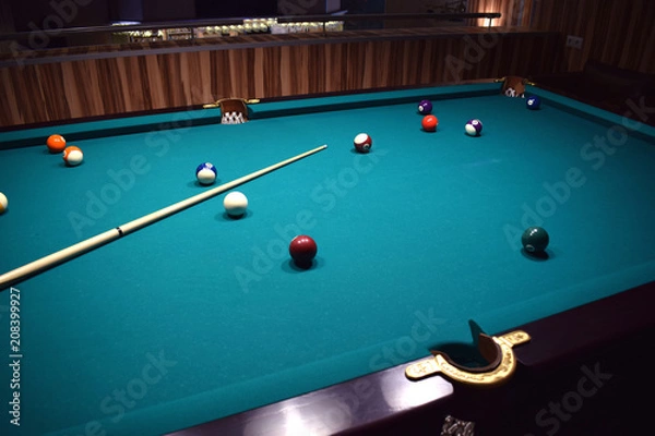 Obraz colored balls of the American pool and cue on the billiard table