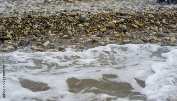 Obraz pebble stones on the sea beach, the rolling waves of the sea with foam