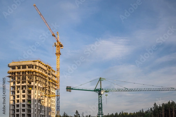 Fototapeta Construction cranes at sunset