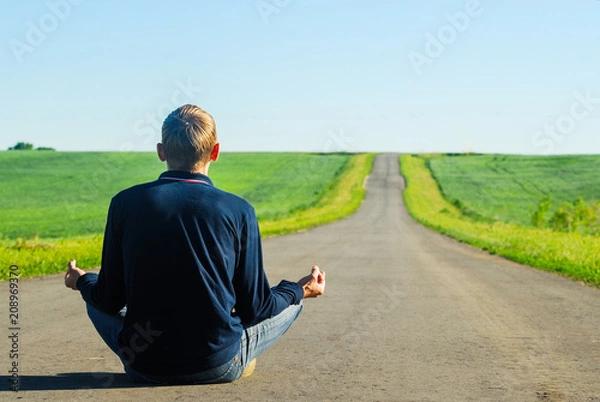 Obraz A single man meditating at sunset