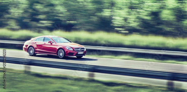 Fototapeta Car driving fast on highway motion blur