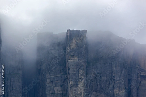 Fototapeta View of Preikestolen steep cliff in fog from the Lysefjorden, Rogaland, Norway