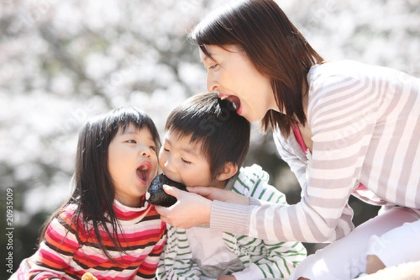 Obraz 子供におにぎりを食べさせる母親