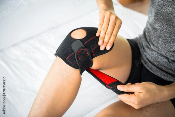 Obraz Women use knee supporter to prevent injuries.