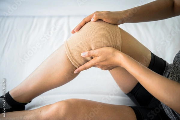Obraz Women use knee supporter to prevent injuries.