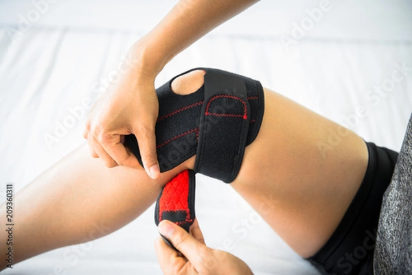Obraz Women use knee supporter to prevent injuries.