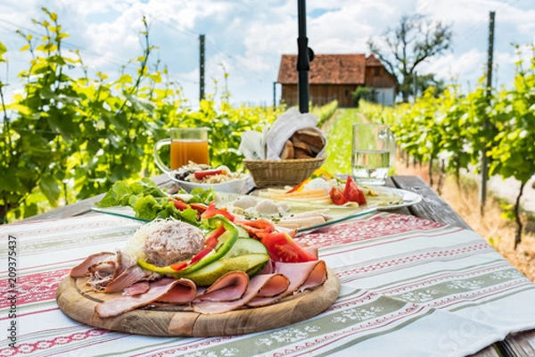 Fototapeta Brettljause, cold plate with meal on wooden table in vineyard