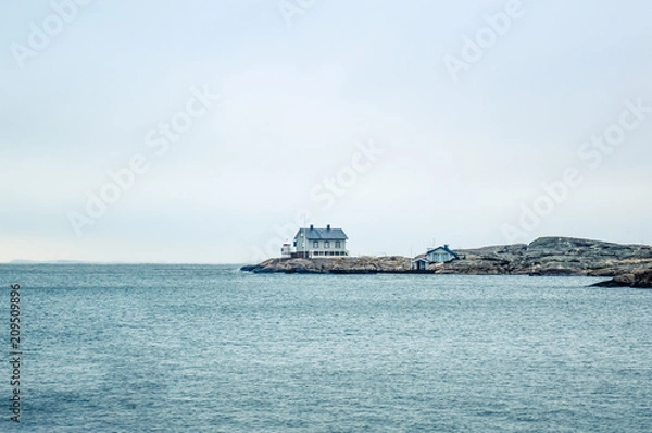 Fototapeta Tiny blue lighthouse on swedish coastline