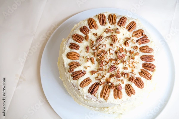 Fototapeta Hummingbird cake with pecans and cream cheese frosting