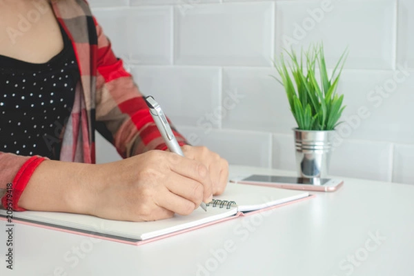 Fototapeta Businesswomen and personal thoughts Write a note on a white desk.