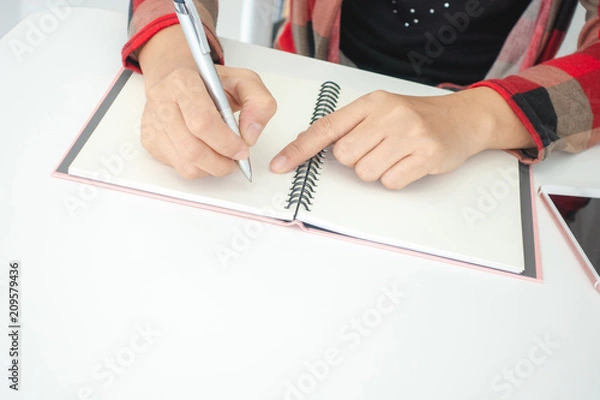 Fototapeta Businesswomen and personal thoughts Write a note on a white desk.