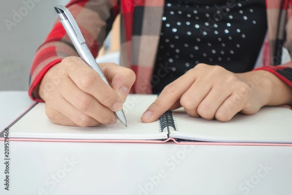 Fototapeta Businesswomen and personal thoughts Write a note on a white desk.