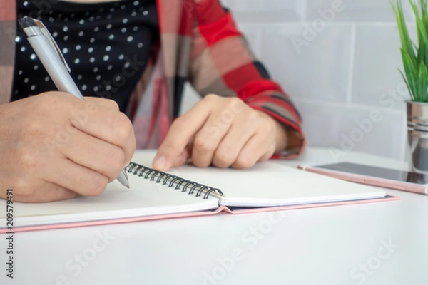 Fototapeta Businesswomen and personal thoughts Write a note on a white desk.