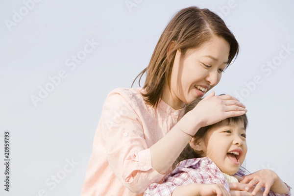 Fototapeta 頭を母親に撫でられる小学生の女の子