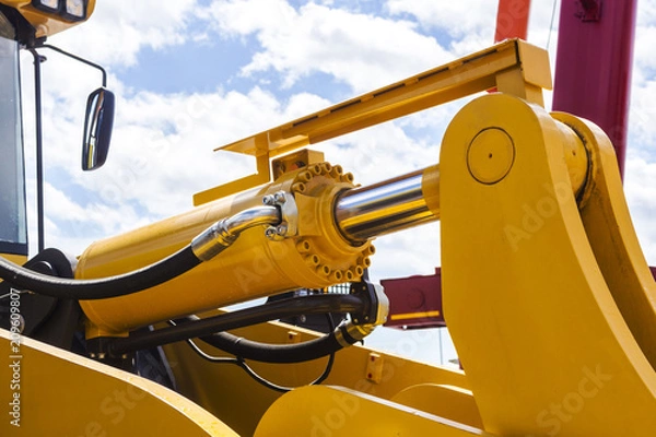 Fototapeta Hydraulic piston system for bulldozers, tractors, excavators, chrome plated cylinder shaft of yellow machine, construction heavy industry detail