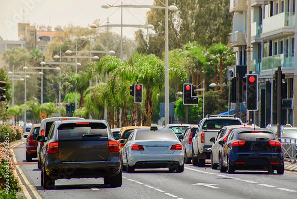 Fototapeta cars stopped at a red traffic light signal in the summer hot midday with a shallow depth of field