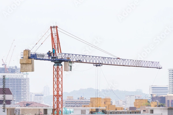 Fototapeta Construction crane, building construction using modern machinery
