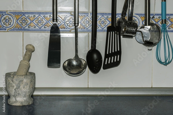 Obraz hung kitchenware and a stone mortar with a tile background