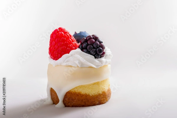 Obraz Mini cheesecake with berries and cream on a white background