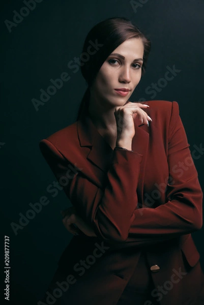 Obraz Portrait of a stylish business woman in a jacket on a dark background