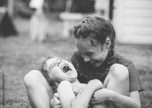 Obraz Two Happy little girls laughing and hugging at the  summer park. Black and white photo