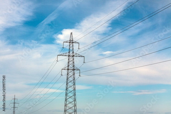 Fototapeta The overhead power line, blue sky and white clouds on the background