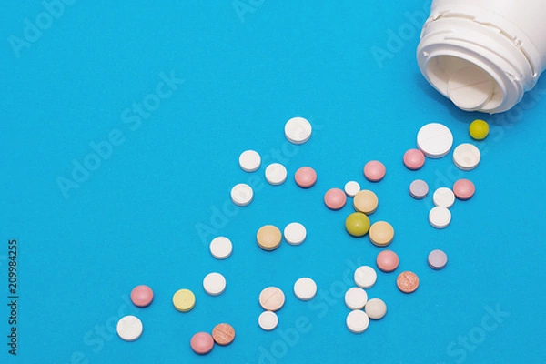 Obraz Bottles of white plastic and a pile of scattered round tablets.