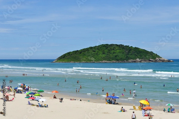 Fototapeta  Tourists in the blue sea with green island background