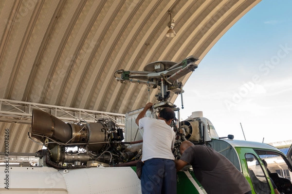 Fototapeta Engineer maintaining a helicopter Engine on the aircraft factory